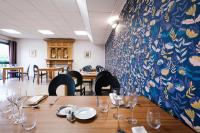 Un comedor con una mesa con copas de vino. en Domaine de Pousiniès, en Saint-Étienne-de-Tulmont