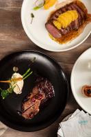 uma mesa com um prato de comida contendo um pedaço de carne em CP Hotel em Dayuan