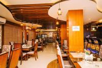 a dining room with wooden tables and chairs at Hotel Tulip Pvt Ltd in Jogīkuti