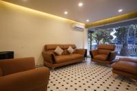 Una sala de estar con dos sillas y un sofá. en Hotel Lotus, en Candolim