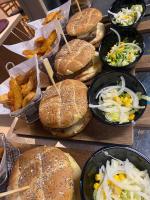 Un montón de sándwiches, ensalada y patatas fritas en una mesa. en Kyriad SEDAN, en Sedan