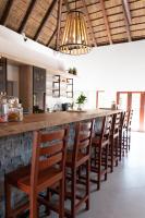 a bar with a row of wooden bar chairs at Mologa River Lodge in Rust de Winter