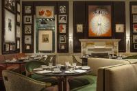 um restaurante com mesas e cadeiras e uma lareira em The Carlyle, A Rosewood Hotel em Nova Iorque