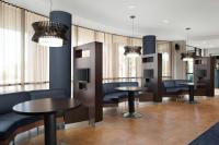 a waiting room with tables and chairs and windows at Courtyard by Marriott Knoxville Airport Alcoa in Alcoa