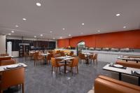 都江堰にあるm designer hotelのテーブルと椅子とキッチンのあるレストラン