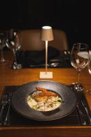 a plate of food on a wooden table with glasses at Ouro Minas Hotel Belo Horizonte, Dolce by Wyndham in Belo Horizonte