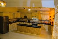 een keuken met houten kasten en een zwarte koelkast bij ELANI Hotel in Samarkand