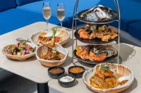 a table with several plates of food and glasses of wine at Kora Beach Resort Phuket in Bang Tao Beach