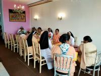 un gruppo di persone seduti intorno a un tavolo in una stanza di hotel saint fracois xavier a Lourdes