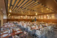 een grote eetkamer met tafels en stoelen bij Echor Himalayan Heights Manali in Manāli