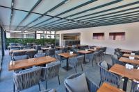 um restaurante vazio com mesas e cadeiras de madeira em Caddem Inn Hotel em Famagusta