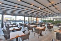 um restaurante com mesas e cadeiras e uma piscina em Caddem Inn Hotel em Famagusta