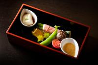 a tray of food with a dipping sauce and vegetables at Wataya Besso in Ureshino
