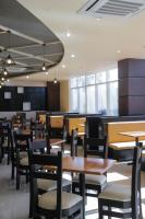 伊洛伊洛Iloilo Gateway Hotel and Suites的配有木桌椅的餐厅