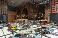 ein Restaurant mit Tischen, Stühlen und Kronleuchtern in der Unterkunft Cassia Rama 9 Bangkok, part of Banyan Group in Bangkok