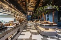 ein Restaurant mit Schachbrettboden in der Unterkunft Cassia Rama 9 Bangkok, part of Banyan Group in Bangkok