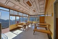 een klaslokaal met tafels en banken in een gebouw bij NAiNi VIEW RESORT in Nainital