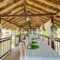 ein langer Tisch mit weißen Stühlen und eine Holzdecke in der Unterkunft Cottage 2 - Appleton Liitle Paradise Beach Resort & Restaurant in Real