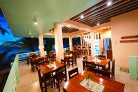 un restaurante con mesas y sillas de madera y el océano en Carabao Island Observatory and Think Tank, en San José