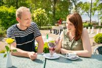 un uomo e una donna seduti a un tavolo di Müritzparadies - Feriendorf Alte Fahrt a Rechlin