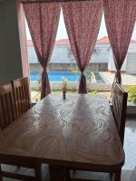 een eettafel met uitzicht op een zwembad bij Prantik Hotel And Resorts in Tajpur