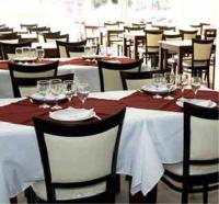 Un comedor con mesas y sillas con copas de vino. en Nuevo Mundo, en San Rafael