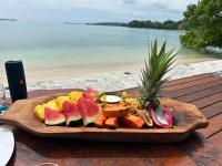 SaraotouExclusive Sunrise Boutique Resort & Private Island- Adults Only - All Inclusive Intimate Island & Santo Experience for Only 9 Couples at a Time的海滩附近的木桌上放上一盘水果