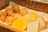 una cesta de pan y croissants y rodajas de naranja en Hotel Global View Hachinohe Annex, en Hachinohe