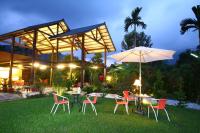 a group of chairs and tables and an umbrella at Zhen Shan Zhuang B&amp;B in Yuanshan