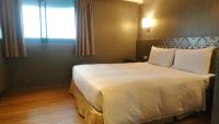 a bedroom with a large white bed with a window at LIHO Hotel Tainan in Tainan