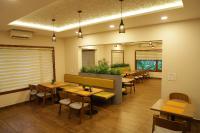 ein Restaurant mit Tischen und Stühlen in einem Raum in der Unterkunft Hortus Malabaricus Garden Resort in Cheruthuruthi