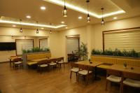 ein Restaurant mit Holztischen, Stühlen und Pflanzen in der Unterkunft Hortus Malabaricus Garden Resort in Cheruthuruthi