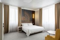 a bedroom with a white bed and a desk and window at Cozy Hotel in Bishkek