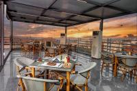 a restaurant with tables and chairs on a balcony at La Veranda Pyramids Boutique Hotel With Rooftop Access in Cairo