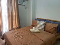 a bedroom with a bed with two towels on it at Verdon Parc Davao City with Balcony by darpm in Davao City