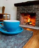 une tasse et une soucoupe bleues sur une table avec une cheminée dans l'établissement Medina River Oaks Courts, à Medina