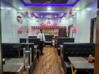 a man standing in a dining room with pink balloons at Hotel Sawai Executive in Jadhavwadi