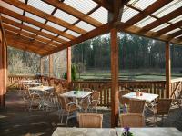 a patio with tables and chairs on a wooden deck at Pension &amp; Gasthaus Kattenstieg in Kattenstiegs-Mühle