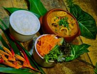 een houten tafel met twee kommen soep en groenten bij Pousada Treze Luas in Ilha do Mel