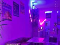 Habitación rosa con sofá y mesa. en NEW GENERATION HOSTEL Navigli Milano, en Milán