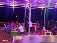 um grupo de pessoas sentadas às mesas de um restaurante em Tulang Diot View Resort and Turtle Haven em Camotes Islands