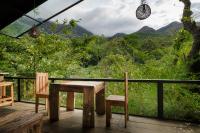 drewniany stół i krzesła na balkonie z widokiem w obiekcie The Glenrock Wellness Nature Resort w mieście Belihul Oya