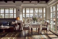 Un comedor con mesa y sillas y ventanas. en Rókusfalvy Borhotel és Fogadó, en Etyek