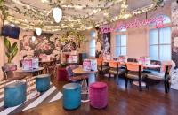 a restaurant with tables and stools in a room at The Royal Hotel Cardiff in Cardiff