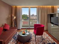 a living room with a couch and a red chair at Hotel de l'Opera Hanoi - MGallery in Hanoi