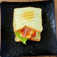 een sandwich wordt doormidden gesneden op een zwarte plaat bij Makarma Resort Lombok in Senggigi 