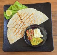 een zwart bord met een tortilla en een kom guacamole bij Makarma Resort Lombok in Senggigi 