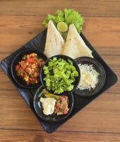een dienblad met drie borden eten op een tafel bij Makarma Resort Lombok in Senggigi 