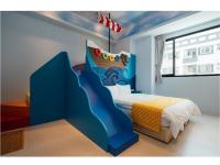 a bedroom with a blue bed with a painting of a waterfall at Yellow Kite Hostel in Tainan
