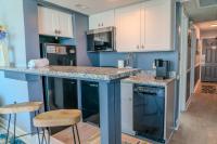 eine Küche mit weißen Schränken und einer Theke mit Stühlen in der Unterkunft Ocean View Double Suite! Sleeps 4 Meridian Plaza 705 in Myrtle Beach